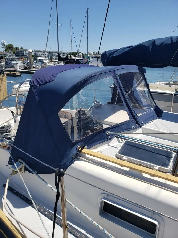 Slide: The Image of 1990 Contessa 32 sailboat with blue cover in harbor. - 10