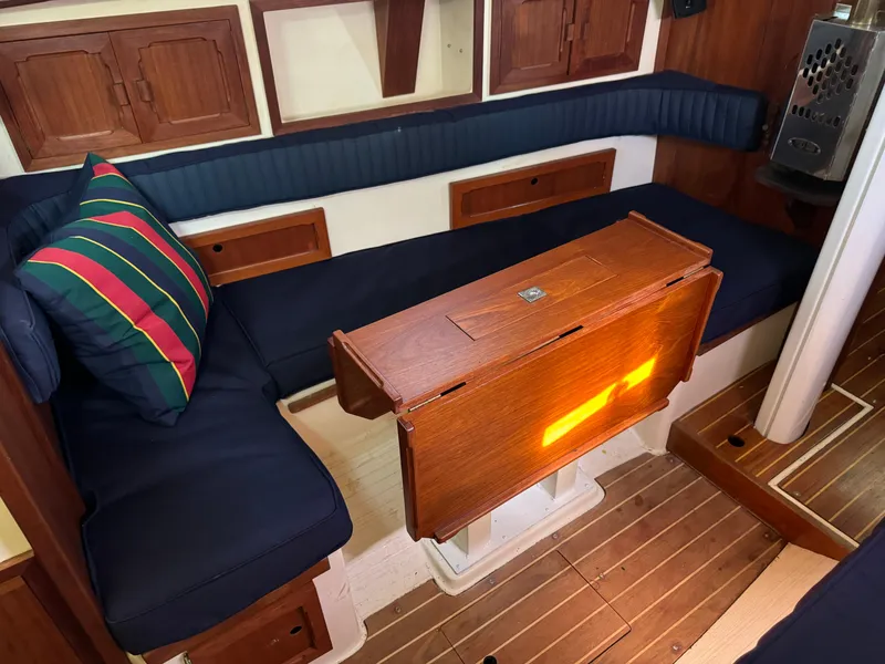 Slide: The Image of Interior of a 1990 Contessa 32 yacht with wooden table and blue cushions. - 16