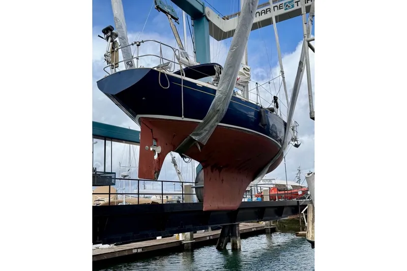 Slide: The Image of Sailboat Contessa 32, 1990 model, lifted in a marina for maintenance. - 32