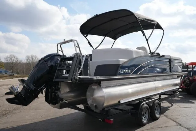Slide: The Image of 2026 Harris Cruiser 230 pontoon boat on trailer, featuring sleek design and powerful outboard motor. - 11