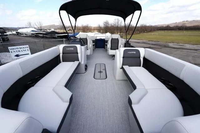 Slide: The Image of 2026 Harris Cruiser 230 pontoon boat with spacious seating and canopy, displayed outdoors. - 14