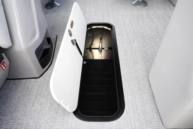 Slide: The Image of 2026 Harris Cruiser 230 boat interior with open storage compartment on carpeted floor. - 17