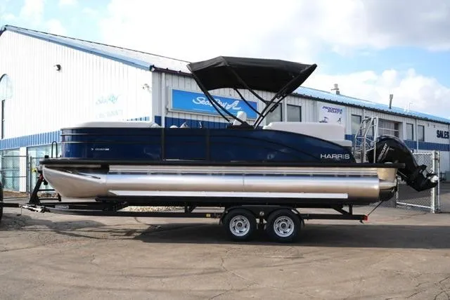 The Image of 2026 Harris Cruiser 230 pontoon boat on trailer outside dealership. - 7