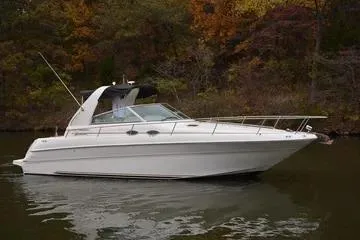The Image of 1998 Sea Ray Sundancer 310 boat on calm water with autumn foliage background. - 0
