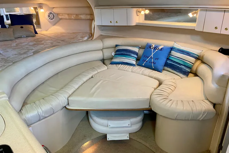 Slide: The Image of 1998 Sea Ray Sundancer 310 interior with cozy seating and decorative pillows. - 14