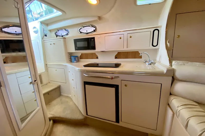 Slide: The Image of Interior of 1998 Sea Ray Sundancer 310 yacht, featuring kitchenette with microwave and sink. - 16