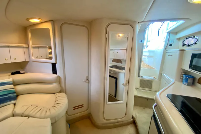 Slide: The Image of Interior of 1998 Sea Ray Sundancer 310 yacht, featuring cozy seating and kitchenette. - 17
