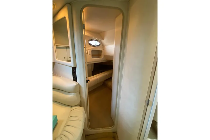 Slide: The Image of 1998 Sea Ray Sundancer 310 cabin interior with cozy seating and porthole window. - 18