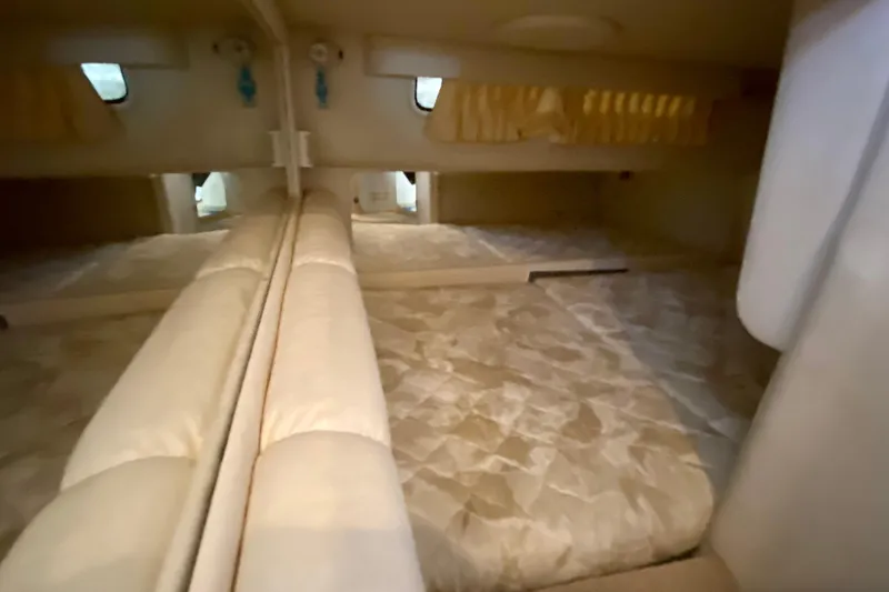 Slide: The Image of 1998 Sea Ray Sundancer 310 cabin interior with beige upholstery and mirrored walls. - 19