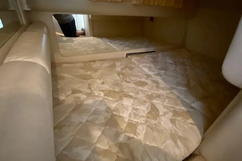 Slide: The Image of 1998 Sea Ray Sundancer 310 cabin interior with beige quilted bedding. - 20