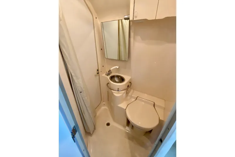 Slide: The Image of Compact bathroom in 1998 Sea Ray Sundancer 310 yacht with sink, toilet, and mirror. - 21