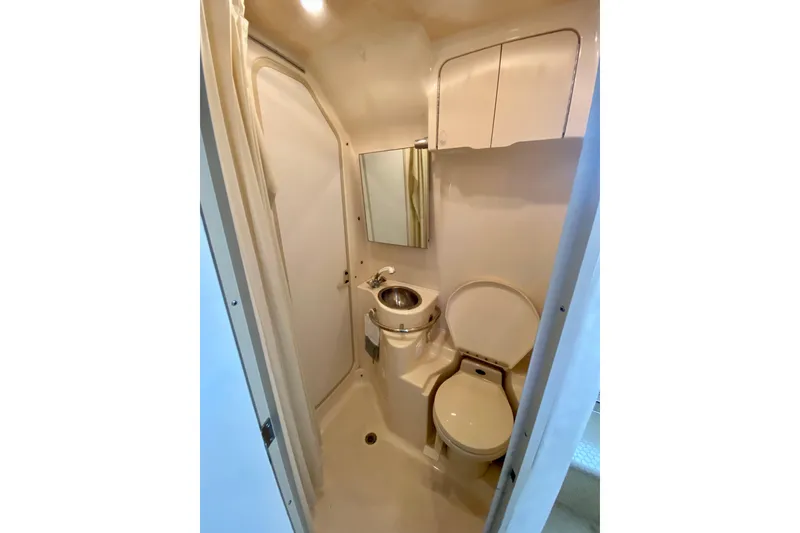 Slide: The Image of 1998 Sea Ray Sundancer 310 bathroom with toilet, sink, and storage cabinets. - 36