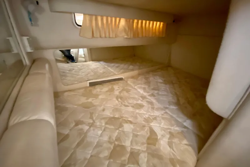 Slide: The Image of 1998 Sea Ray Sundancer 310 cabin interior with cozy bedding and soft lighting. - 38