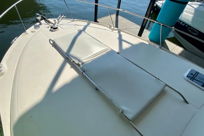 Slide: The Image of 1998 Sea Ray Sundancer 310 boat deck with sun pad, docked by the water. - 5