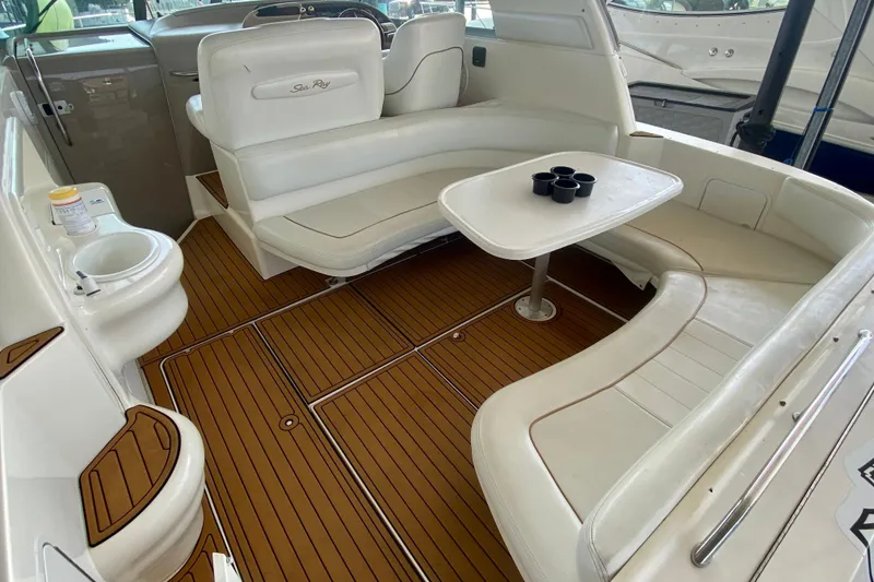 Slide: The Image of 1998 Sea Ray Sundancer 310 interior with white seating, wooden flooring, and a central table. - 8