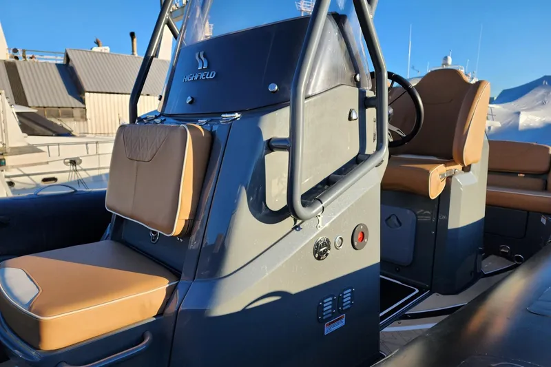 Slide: The Image of 2026 Highfield Escape 650 boat interior with tan seating and modern controls. - 11