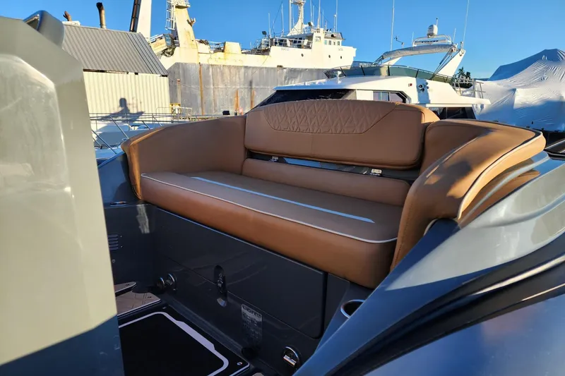 Slide: The Image of Highfield Escape 650 (2026) boat with luxurious tan seating, docked in a marina. - 13