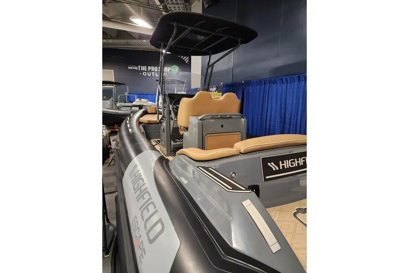 Slide: The Image of 2026 Highfield Escape 650 boat displayed indoors with tan seating and sleek design. - 5