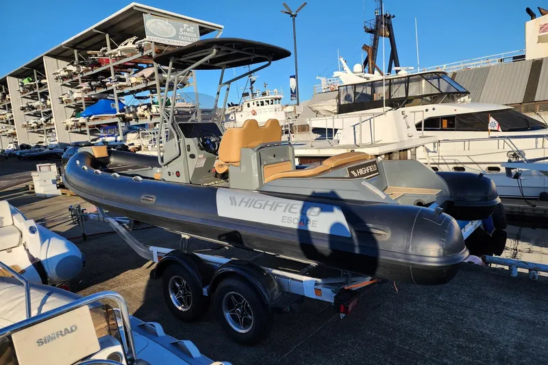 Slide: The Image of 2026 Highfield Escape 650 boat on trailer at marina, surrounded by yachts. - 8