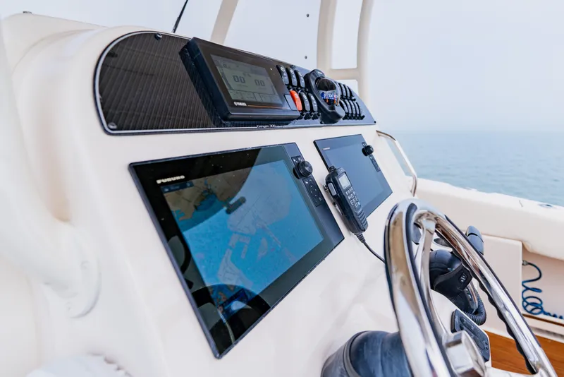 Slide: The Image of Control panel of 2021 Grady-White Canyon 306 boat with navigation screens and steering wheel. - 24