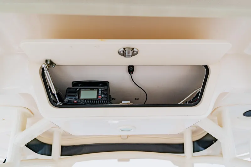Slide: The Image of 2021 Grady-White Canyon 306 boat storage compartment with electronic equipment. - 27