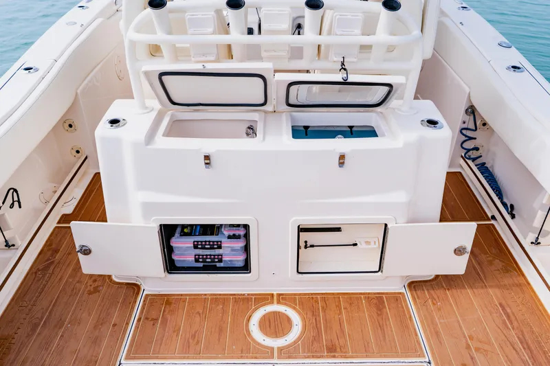 Slide: The Image of 2021 Grady-White Canyon 306 boat interior with storage compartments and wooden deck. - 34