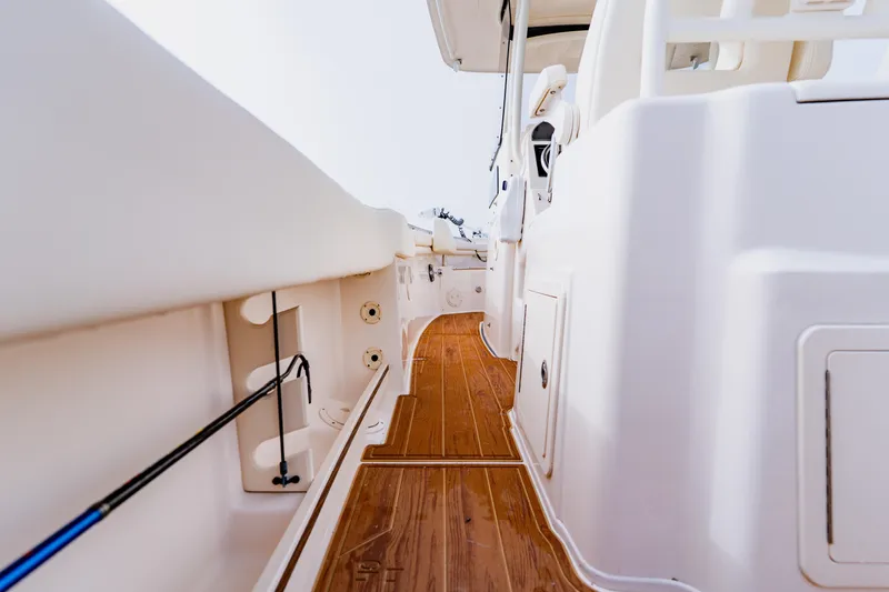 Slide: The Image of 2021 Grady-White Canyon 306 boat interior with wooden deck and fishing rod holder. - 35