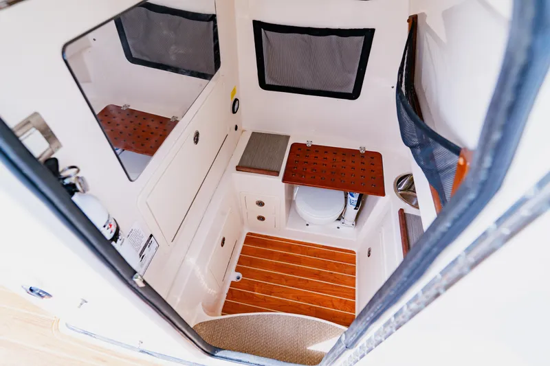 Slide: The Image of 2021 Grady-White Canyon 306 boat interior with compact bathroom and wooden flooring. - 45