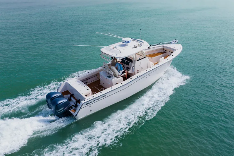 Slide: The Image of 2021 Grady-White Canyon 306 boat cruising on open water, featuring dual Yamaha engines. - 5