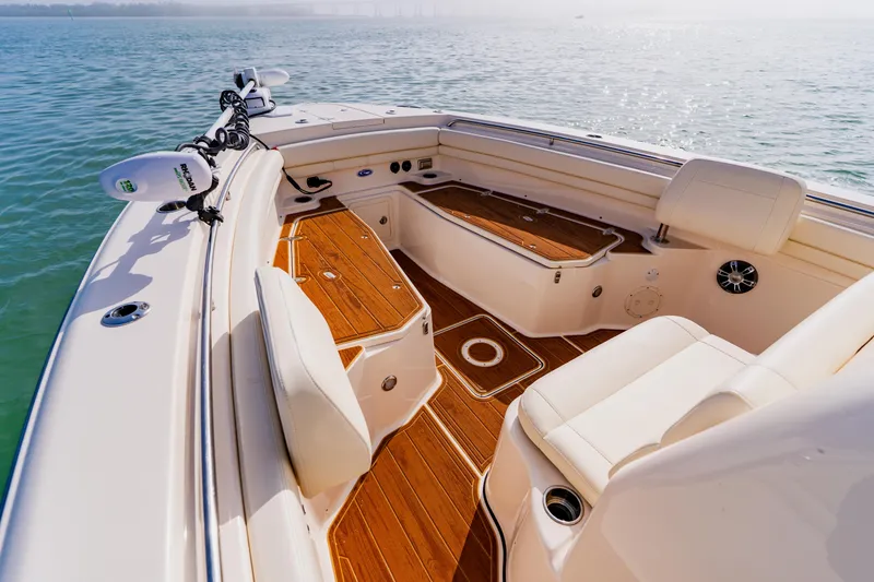 Slide: The Image of 2021 Grady-White Canyon 306 boat interior with teak flooring and seating on calm water. - 7