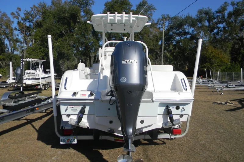 Slide: The Image of 2022 Sea Hunt Ultra 234 boat with Yamaha 200 engine, parked on grass. - 2