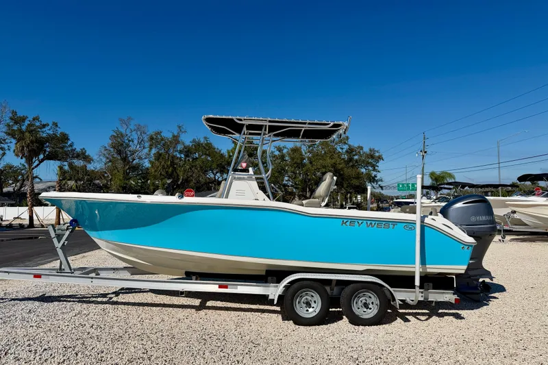 The Image of 2023 Key West 239 FS boat on trailer, vibrant blue hull, parked outdoors. - 0