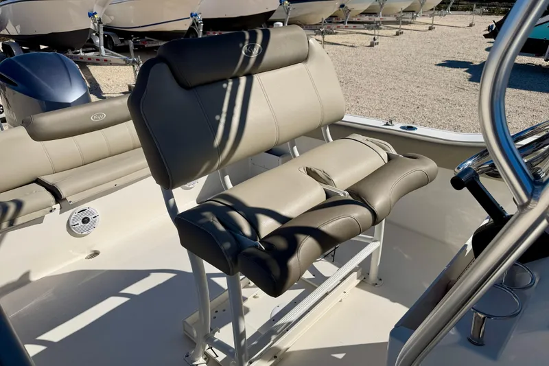 Slide: The Image of 2023 Key West 239 FS boat interior with beige seating and steering wheel. - 15