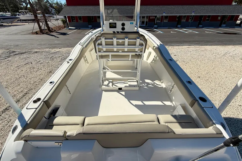 Slide: The Image of 2023 Key West 239 FS boat interior with seating and console, parked outdoors. - 26