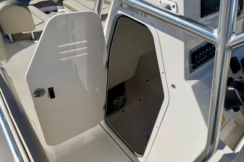 Slide: The Image of 2023 Key West 239 FS boat console storage compartment with open door. - 33