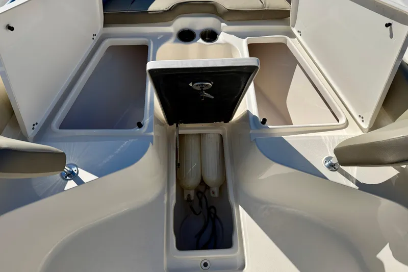 Slide: The Image of 2023 Key West 239 FS boat storage compartments with open hatches and visible fenders. - 35