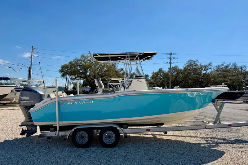 Slide: The Image of 2023 Key West 239 FS boat on trailer, vibrant blue hull, parked outdoors. - 4