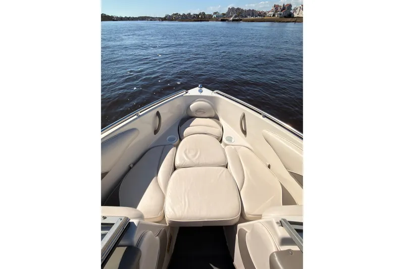 Slide: The Image of 2003 Crownline 180 BR boat interior with beige seating on calm water. - 4