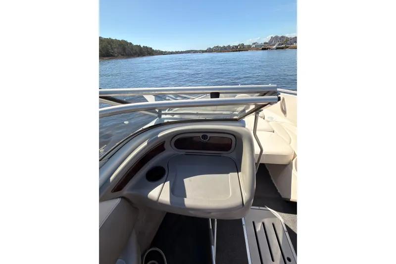 Slide: The Image of 2003 Crownline 180 BR boat interior with lake view, featuring seating and dashboard. - 6