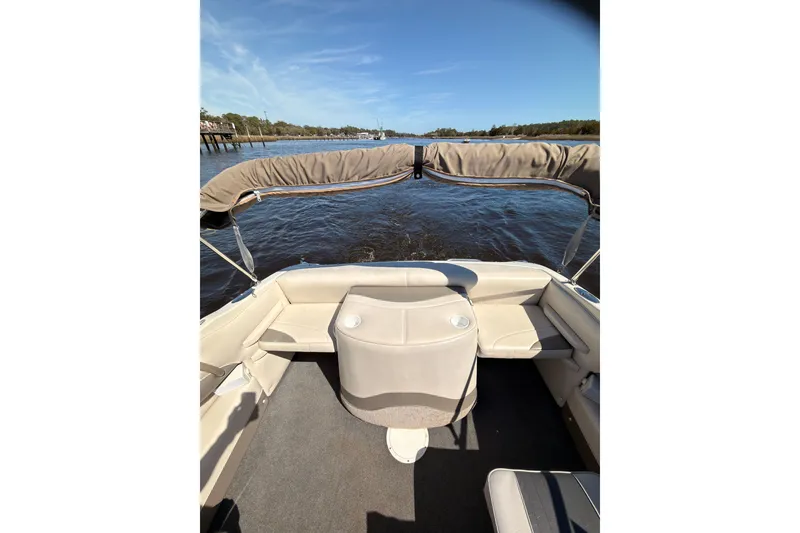 Slide: The Image of 2003 Crownline 180 BR boat interior with beige seating, cruising on a sunny day. - 8