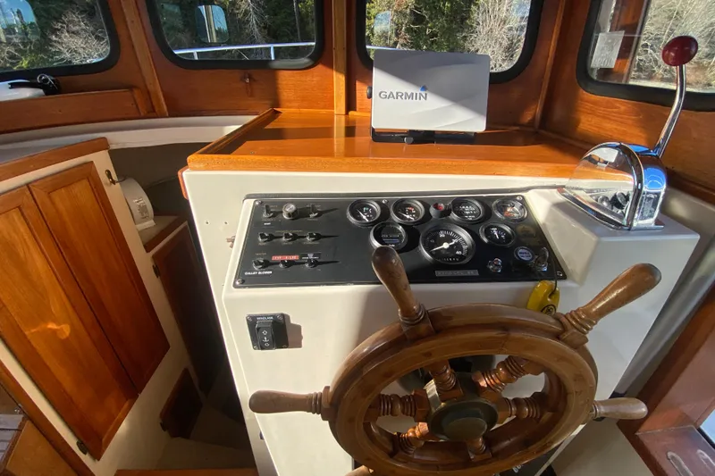 Slide: The Image of 1988 Nordic Tug 26 helm with wooden wheel, gauges, and Garmin navigation system. - 14
