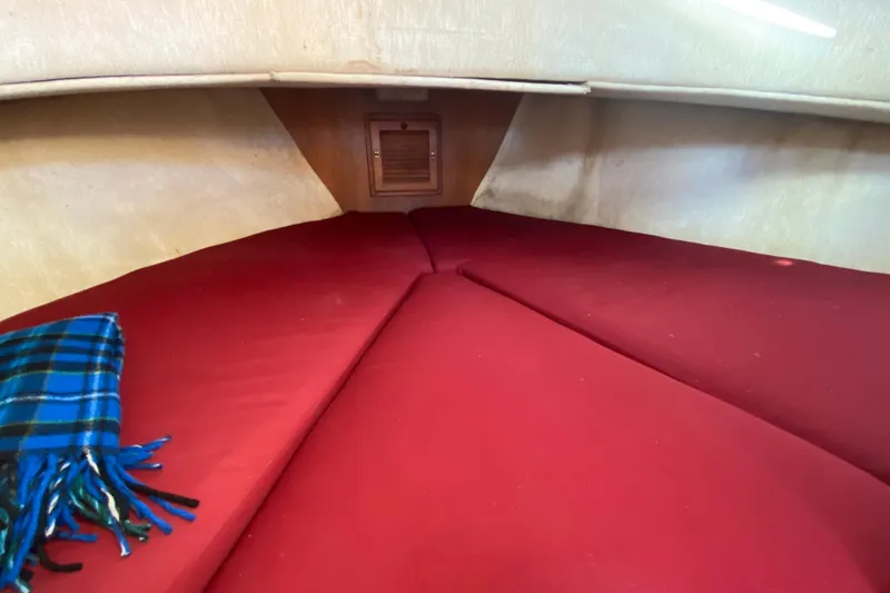 Slide: The Image of Cozy cabin interior of 1988 Nordic Tug 26 with red cushions and plaid blanket. - 19