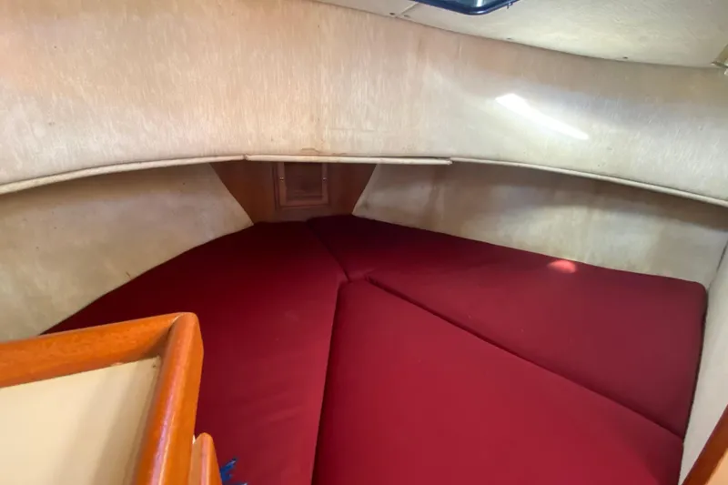 Slide: The Image of 1988 Nordic Tug 26 interior cabin with red cushions and wooden accents. - 20