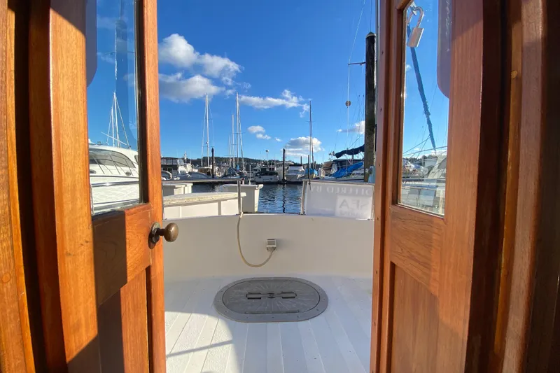 Slide: The Image of View from Nordic Tug 26, 1988 model, overlooking marina with clear blue sky. - 27