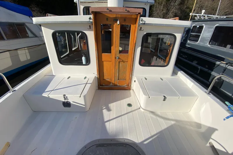 Slide: The Image of 1988 Nordic Tug 26 boat deck with wooden door and storage compartments. - 3