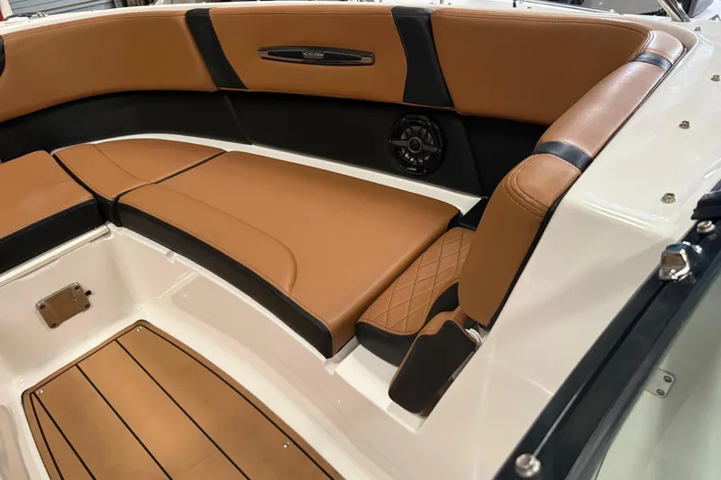 Slide: The Image of 2022 Chaparral 307 SSX boat interior with tan and black seating, featuring a speaker. - 10