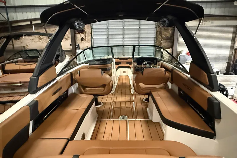 Slide: The Image of 2022 Chaparral 307 SSX boat interior with tan seating and sleek design. - 14
