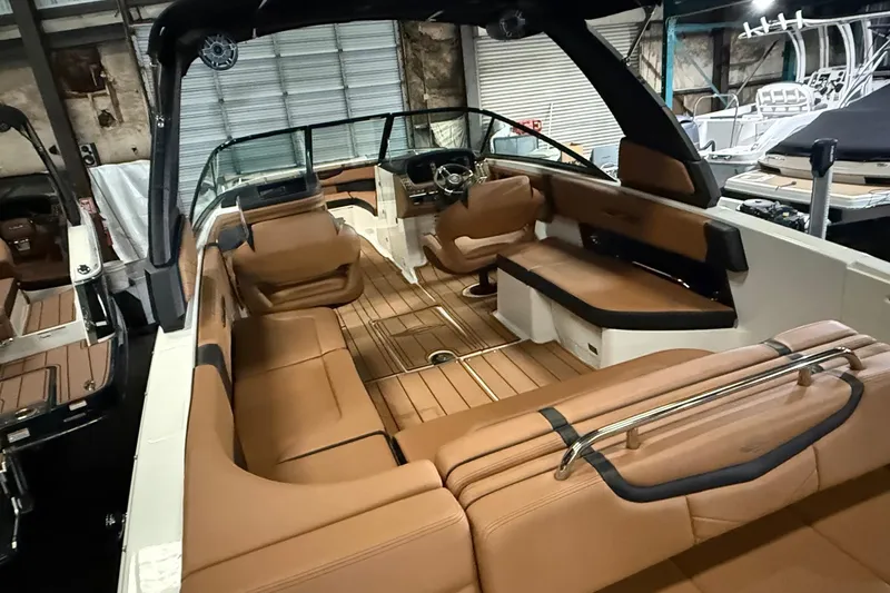 Slide: The Image of 2022 Chaparral 307 SSX boat interior with tan seating and sleek design. - 19