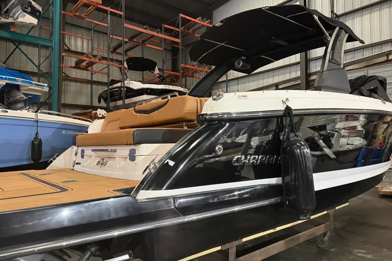 Slide: The Image of 2022 Chaparral 307 SSX boat in storage, featuring sleek design and luxurious seating. - 2