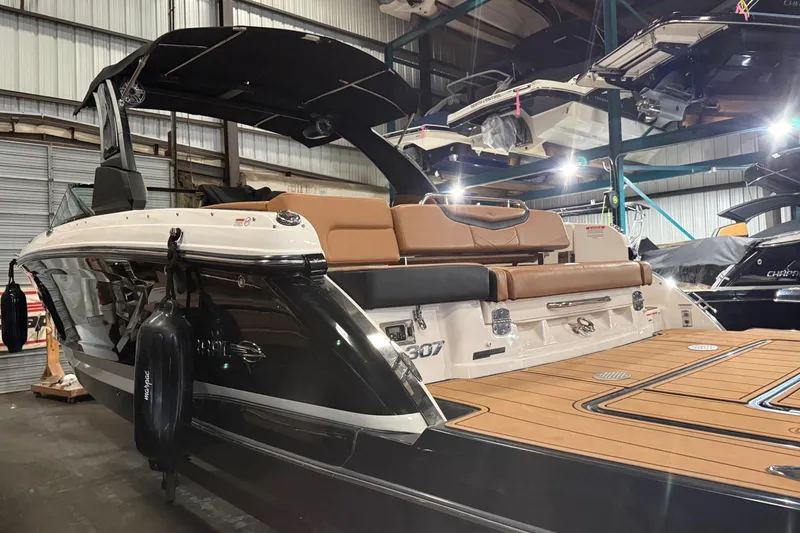 Slide: The Image of 2022 Chaparral 307 SSX boat in showroom, featuring sleek design and luxurious seating. - 3